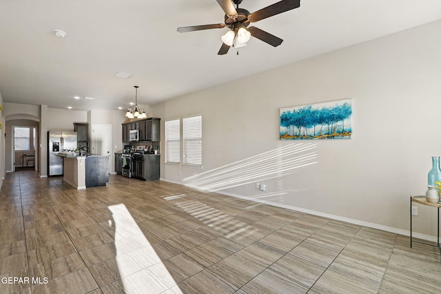 1021 Aerodyne Pl, El Paso, TX 79928 - unfurnished living room with a ceiling fan, healthy amount of natural light, baseboards, and a chandelier