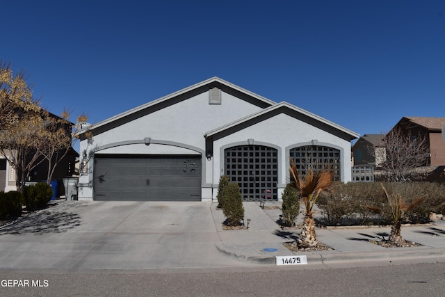 ranch-style home with an attached garage, driveway, and stucco siding
