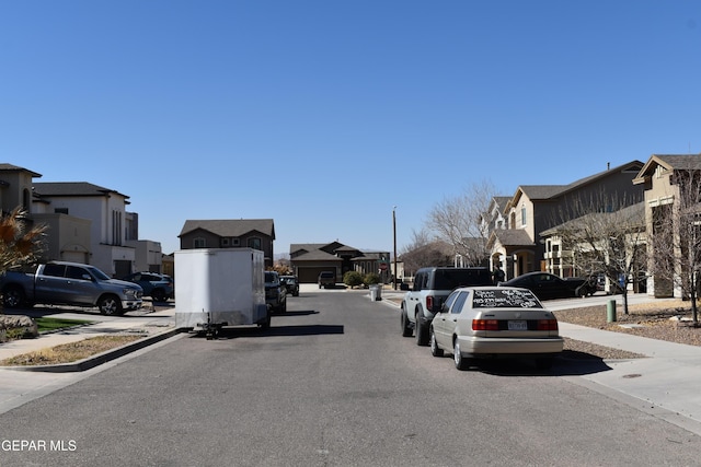 view of road featuring curbs, sidewalks, and a residential view