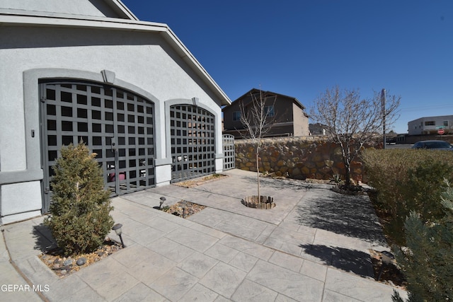 view of patio / terrace with a garage and fence
