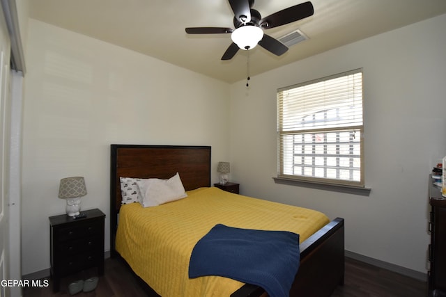 bedroom with a ceiling fan, baseboards, and dark wood-type flooring