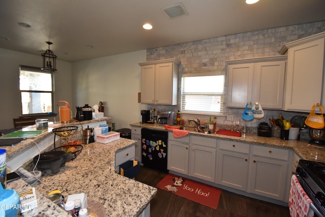 kitchen featuring gas range, light stone counters, black dishwasher, and visible vents
