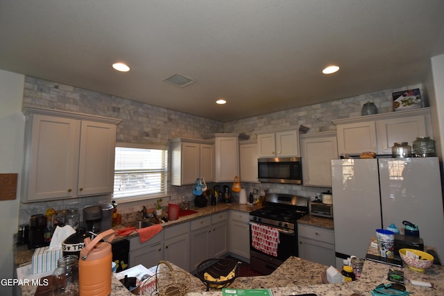 kitchen with stainless steel appliances, visible vents, decorative backsplash, and recessed lighting