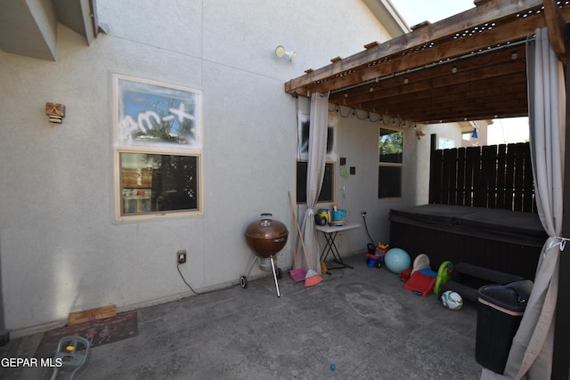 view of patio with fence and a hot tub
