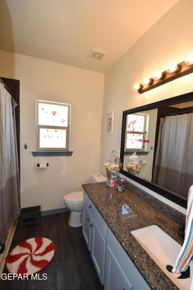 bathroom with visible vents, vanity, baseboards, toilet, and a shower with shower curtain