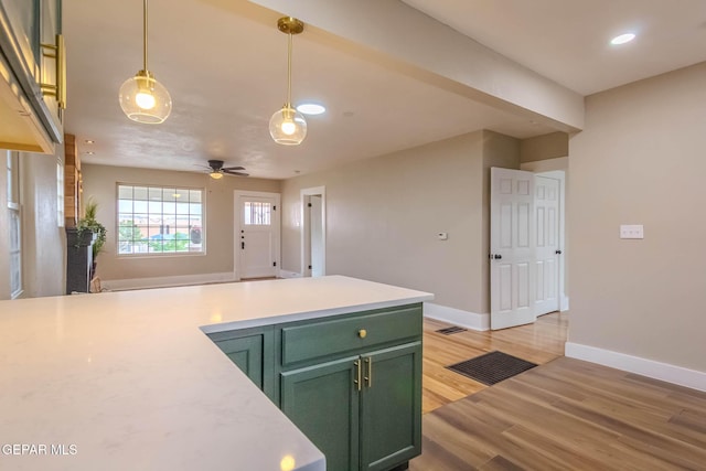 kitchen featuring light countertops, recessed lighting, green cabinetry, and light wood finished floors
