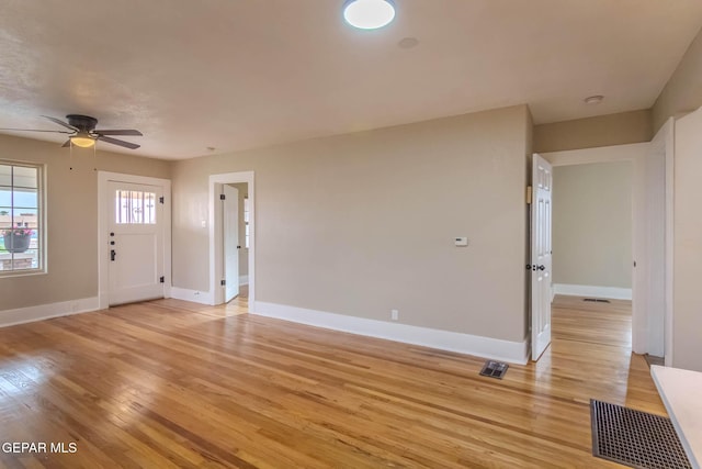 unfurnished living room featuring baseboards and light wood-type flooring