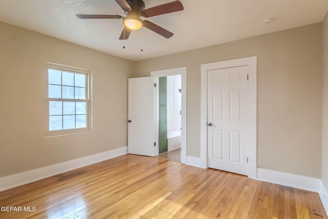 unfurnished bedroom with baseboards, ceiling fan, light wood-style flooring, and connected bathroom