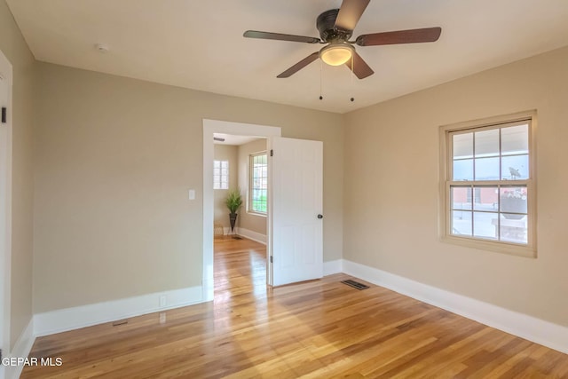 spare room featuring baseboards, visible vents, ceiling fan, and light wood-style floors