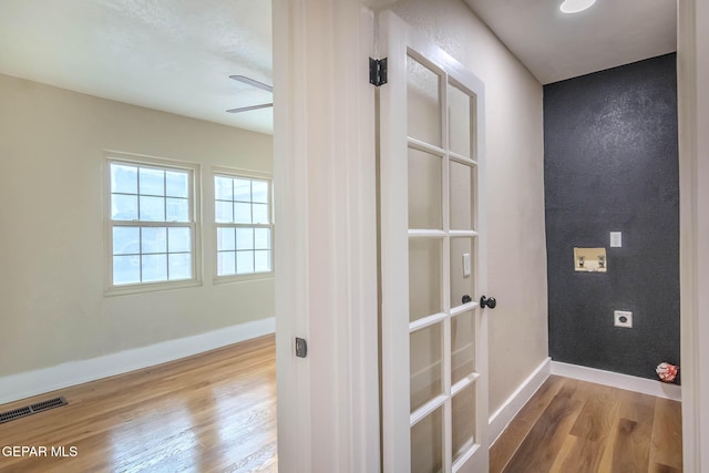 interior space featuring baseboards, ceiling fan, wood finished floors, and visible vents