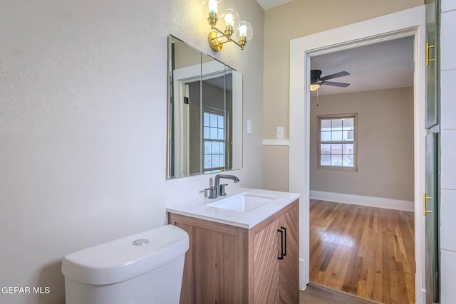 bathroom featuring vanity, a ceiling fan, wood finished floors, and toilet