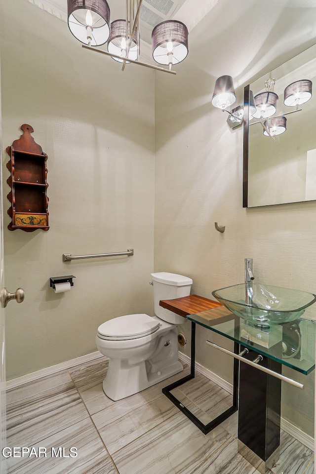 624 Mount Cristo Rey Ln, El Paso, TX 79922 - bathroom featuring toilet, baseboards, a sink, and a chandelier