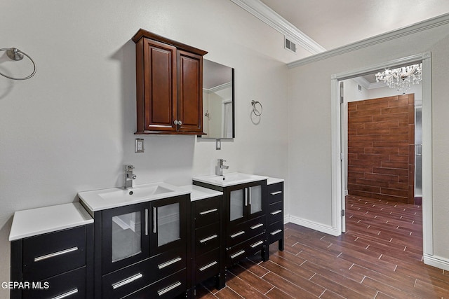 624 Mount Cristo Rey Ln, El Paso, TX 79922 - bathroom with wood finished floors, crown molding, a chandelier, two vanities, and baseboards