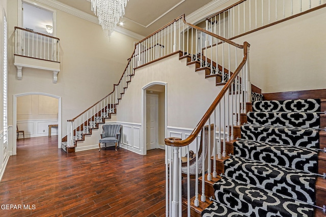624 Mount Cristo Rey Ln, El Paso, TX 79922 - stairway with arched walkways, a towering ceiling, hardwood / wood-style flooring, ornamental molding, and a decorative wall