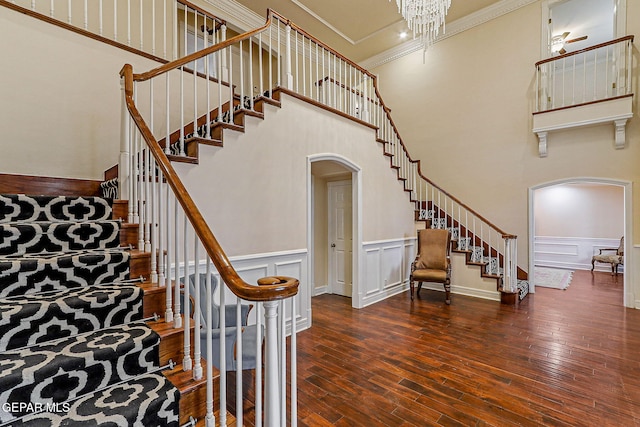 624 Mount Cristo Rey Ln, El Paso, TX 79922 - stairway featuring arched walkways, a towering ceiling, hardwood / wood-style flooring, ornamental molding, and wainscoting