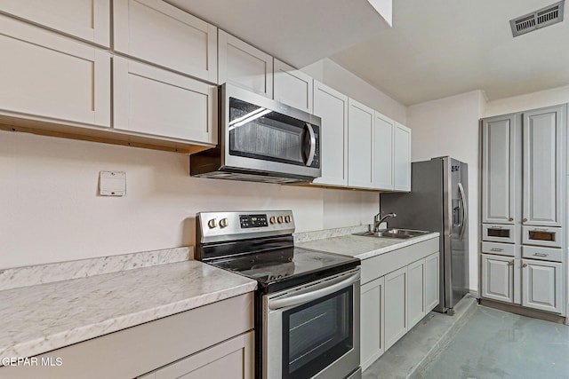 624 Mount Cristo Rey Ln, El Paso, TX 79922 - kitchen featuring stainless steel appliances, finished concrete flooring, a sink, and light countertops