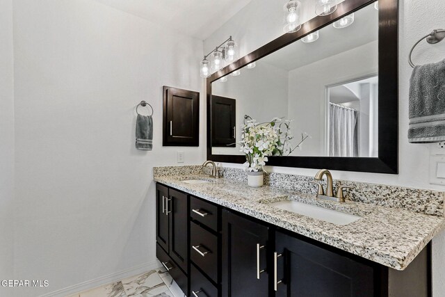 bathroom featuring a sink, baseboards, double vanity, and marble finish floor