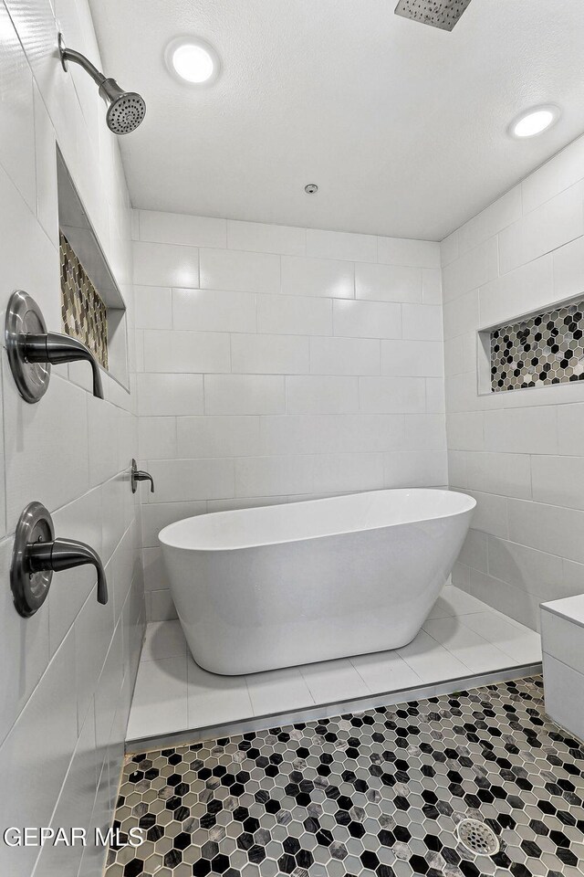 bathroom featuring a freestanding bath, tile walls, a tile shower, and recessed lighting