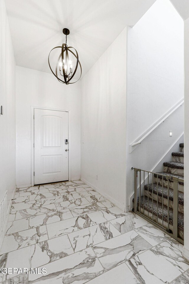 entrance foyer with stairway, a chandelier, baseboards, and marble finish floor