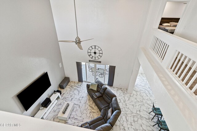 interior space featuring a high ceiling, ceiling fan, and marble finish floor