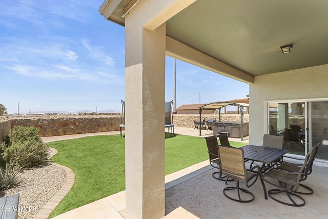 view of patio with a fenced backyard, outdoor dining space, and a hot tub