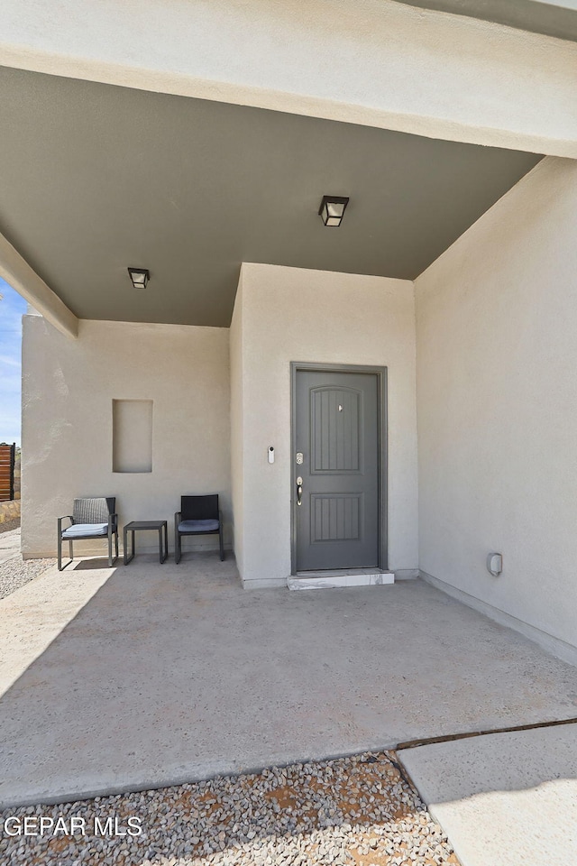 doorway to property featuring a patio and stucco siding