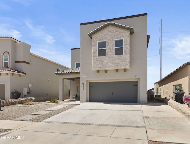 view of front of house featuring a garage, stone siding, stucco siding, driveway, and a tile roof