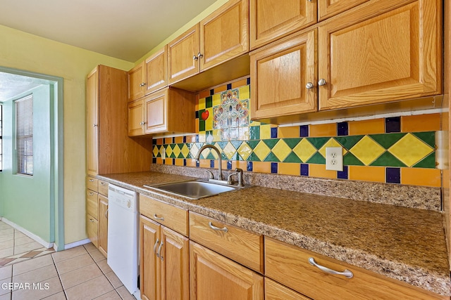 kitchen with decorative backsplash, dishwasher, baseboards, a sink, and light tile patterned floors