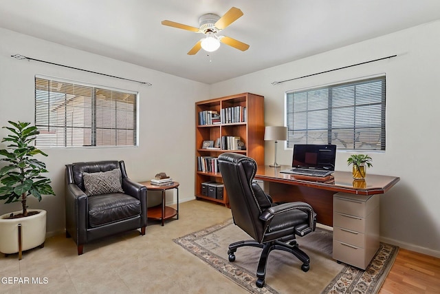office featuring a healthy amount of sunlight, baseboards, and ceiling fan