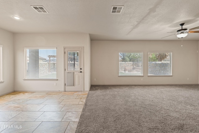 interior space with visible vents, a ceiling fan, and a textured ceiling