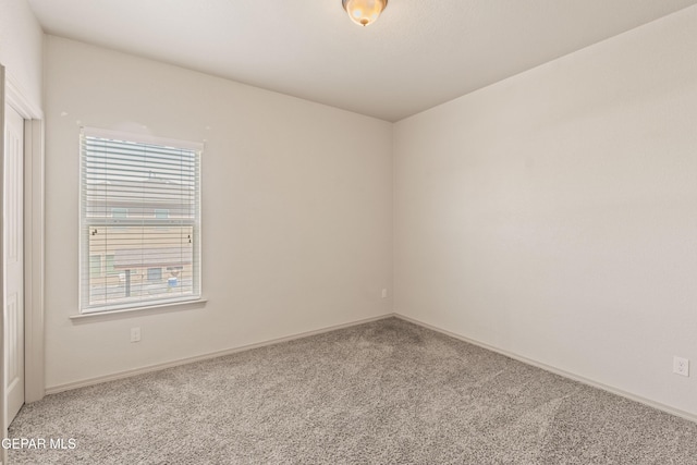 spare room with baseboards, carpet flooring, and a healthy amount of sunlight