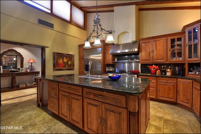 5401 Tierra Vista Dr, El Paso, TX 79932 - kitchen with stainless steel built in refrigerator, wall chimney exhaust hood, a towering ceiling, decorative backsplash, and a center island with sink