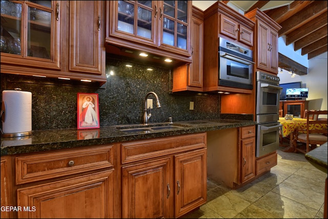 5401 Tierra Vista Dr, El Paso, TX 79932 - kitchen featuring a sink, double oven, decorative backsplash, glass insert cabinets, and dark stone countertops