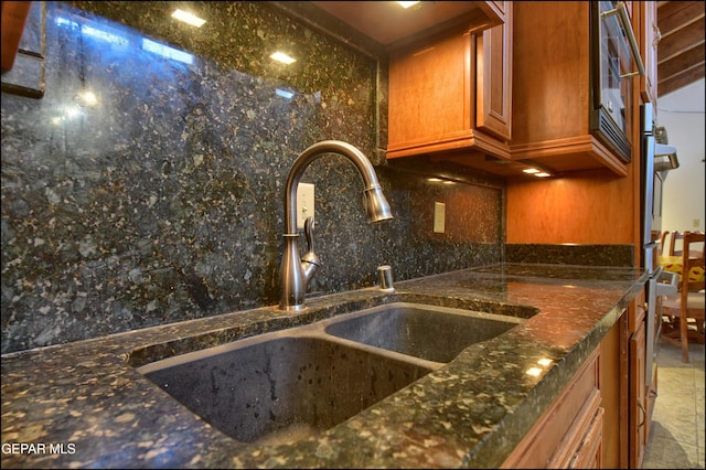 5401 Tierra Vista Dr, El Paso, TX 79932 - kitchen featuring a sink, tasteful backsplash, dark stone countertops, and brown cabinets