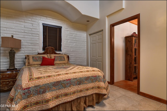 5401 Tierra Vista Dr, El Paso, TX 79932 - bedroom featuring light tile patterned floors, brick wall, and baseboards