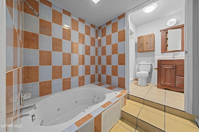 4808 Sagittarius Ave, El Paso, TX 79924 - bathroom with vanity, toilet, tile patterned floors, a jetted tub, and tile walls