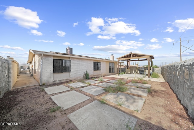 4808 Sagittarius Ave, El Paso, TX 79924 - rear view of property featuring a gazebo, brick siding, a gate, a chimney, and a patio