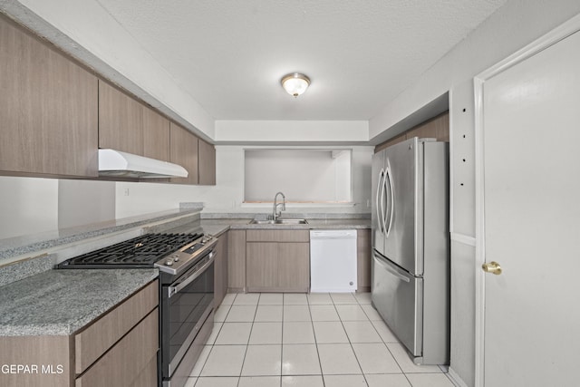 4808 Sagittarius Ave, El Paso, TX 79924 - kitchen with light brown cabinetry, a sink, under cabinet range hood, stainless steel appliances, and light tile patterned flooring