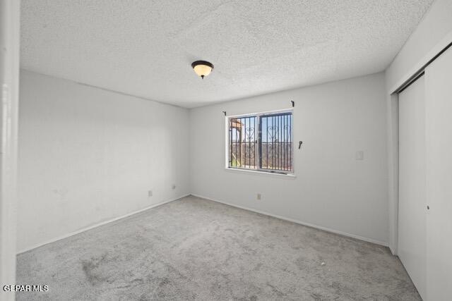 4808 Sagittarius Ave, El Paso, TX 79924 - empty room with carpet floors, a textured ceiling, and baseboards