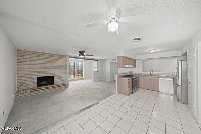 4808 Sagittarius Ave, El Paso, TX 79924 - kitchen with a textured ceiling, light colored carpet, appliances with stainless steel finishes, a sink, and open floor plan
