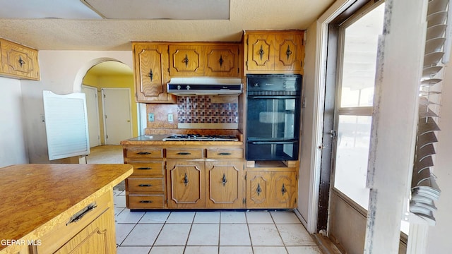 6001 Canton Ct, El Paso, TX 79905 - kitchen featuring a warming drawer, under cabinet range hood, brown cabinets, and oven