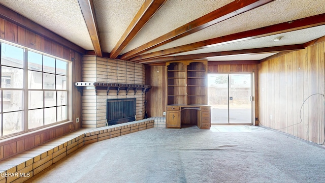 6001 Canton Ct, El Paso, TX 79905 - unfurnished living room featuring wooden walls, a brick fireplace, carpet floors, and beam ceiling
