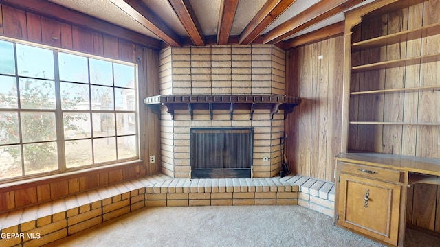 6001 Canton Ct, El Paso, TX 79905 - unfurnished living room featuring wood walls, carpet, a healthy amount of sunlight, and a fireplace