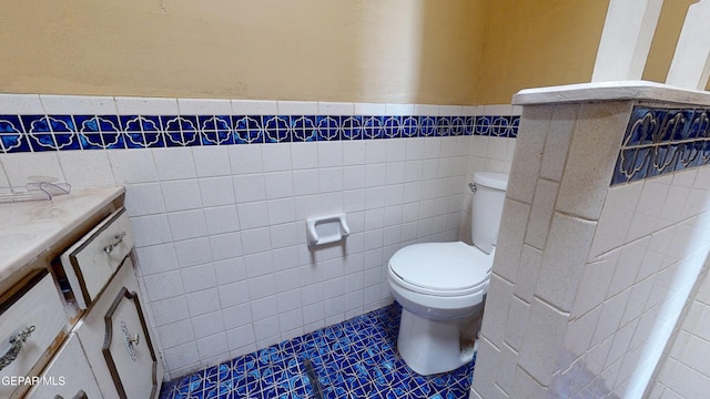 6001 Canton Ct, El Paso, TX 79905 - half bathroom featuring tile walls, wainscoting, tile patterned floors, vanity, and toilet