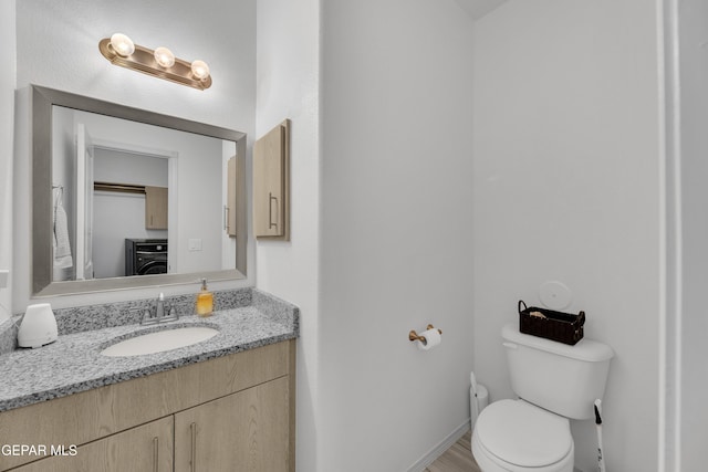 bathroom with vanity, toilet, and washer / clothes dryer