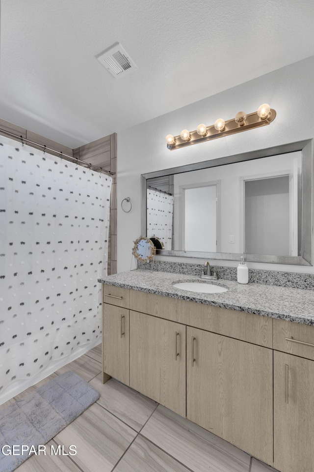 full bathroom featuring visible vents, curtained shower, and vanity