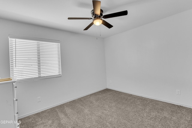 spare room with carpet floors, ceiling fan, and baseboards