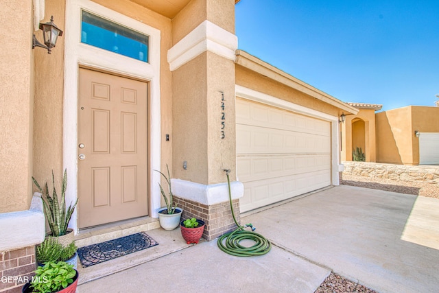 14253 Hacienda Rock Dr, El Paso, TX 79938 - property entrance with stucco siding, concrete driveway, and a garage