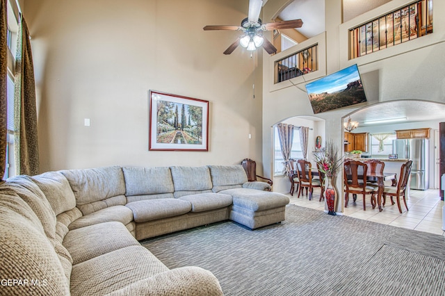 14253 Hacienda Rock Dr, El Paso, TX 79938 - living area featuring light tile patterned floors, arched walkways, ceiling fan, and a towering ceiling