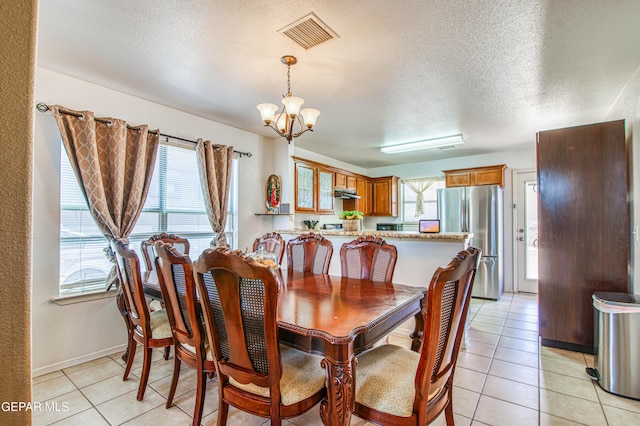 14253 Hacienda Rock Dr, El Paso, TX 79938 - dining area featuring a chandelier, light tile patterned floors, a textured ceiling, and baseboards
